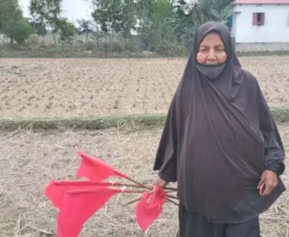 নিজ জমিতে লাল পতাকা হাতে বীরাঙ্গনা মাজেদা নিজ জমিতে লাল পতাকা হাতে বীরাঙ্গনা মাজেদা