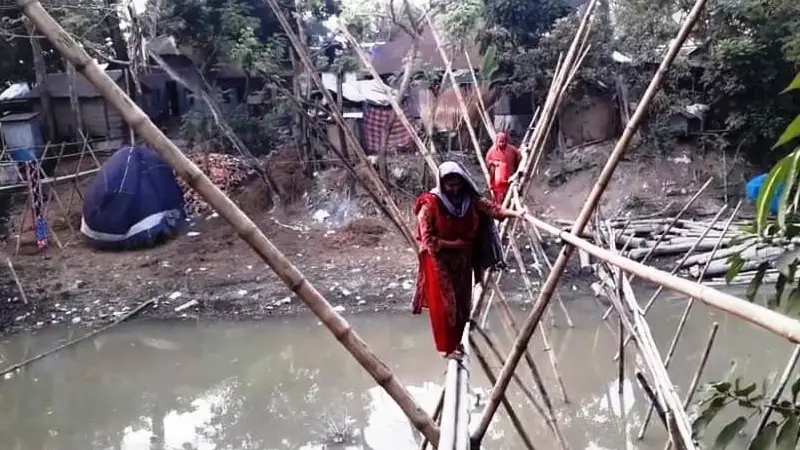 বাঁশের সাঁকোই ভরসা, ঝুঁকি নিয়ে পার হচ্ছে নারী-পুরুষরা বাঁশের সাঁকোই ভরসা, ঝুঁকি নিয়ে পার হচ্ছে নারী-পুরুষরা